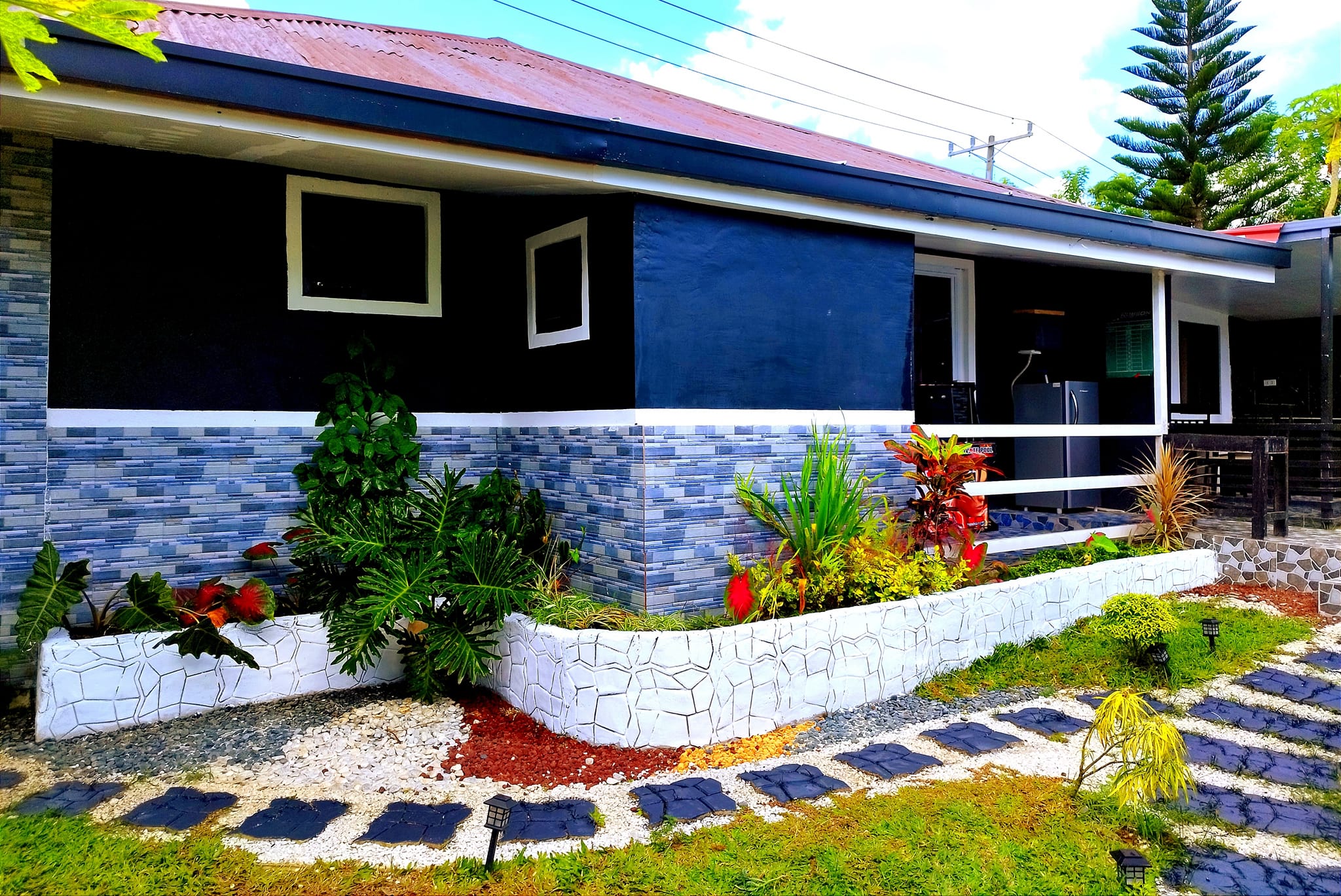 Athena's Guesthouse exterior with blue tile accents and landscaped garden