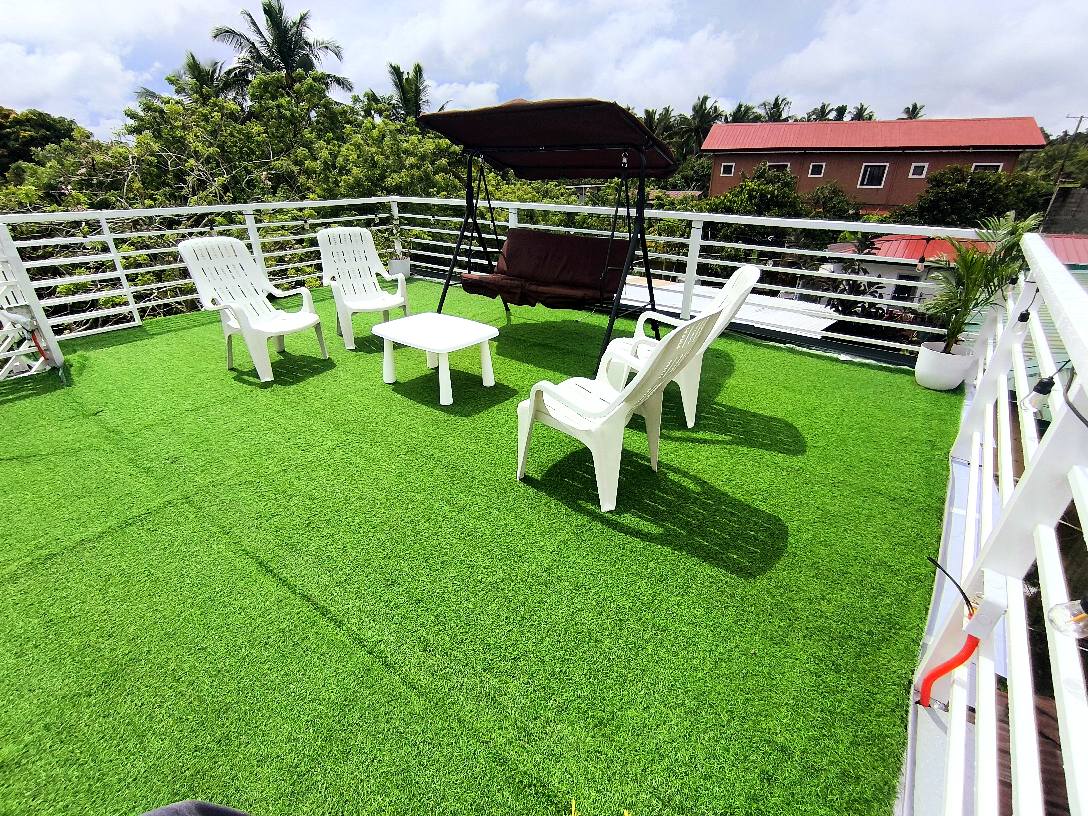 Rooftop lounge with chairs and swing overlooking greenery