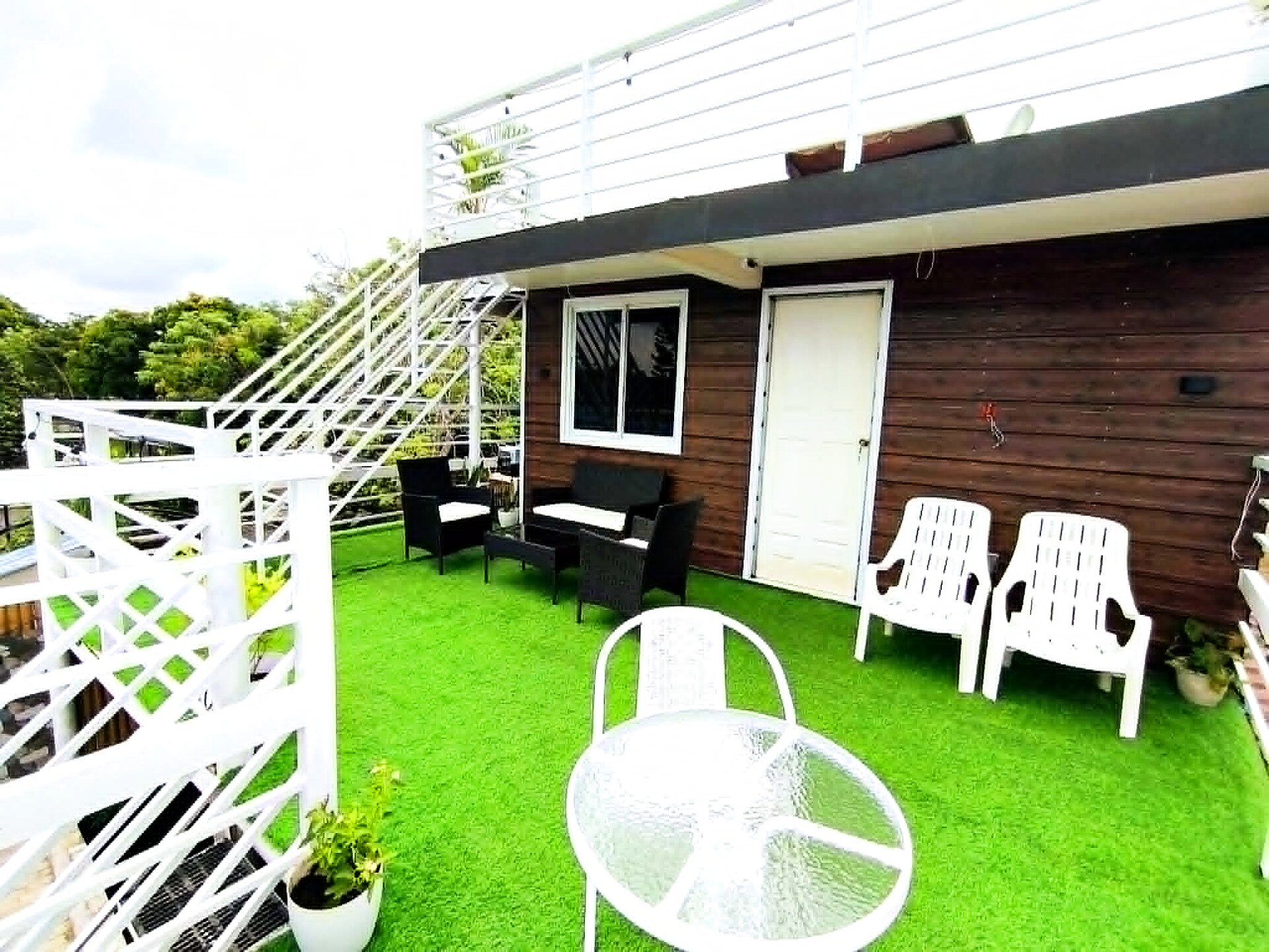 Sunny rooftop deck with lounge seating and white railings