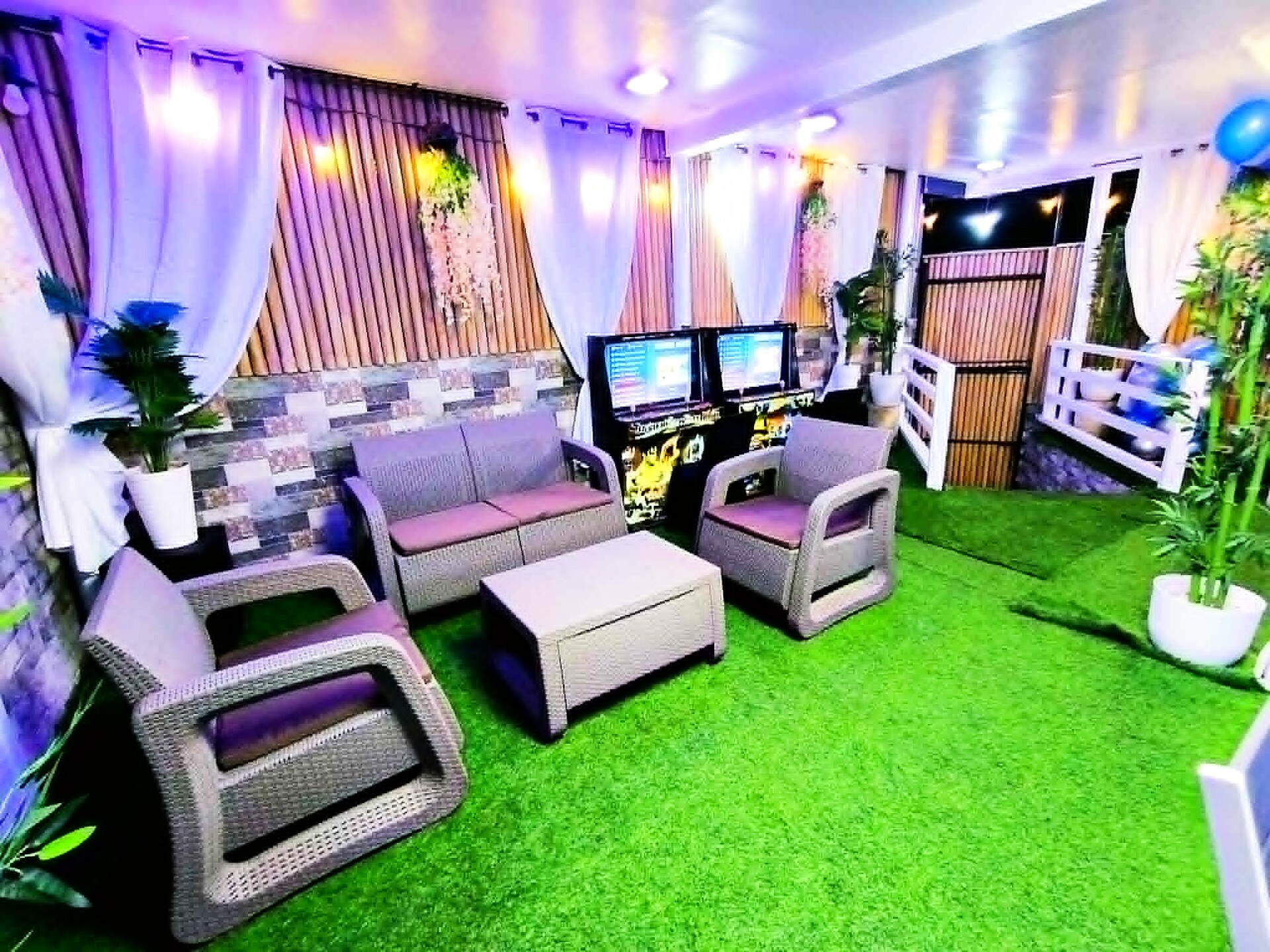 Cozy karaoke lounge with sofas and warm purple lighting