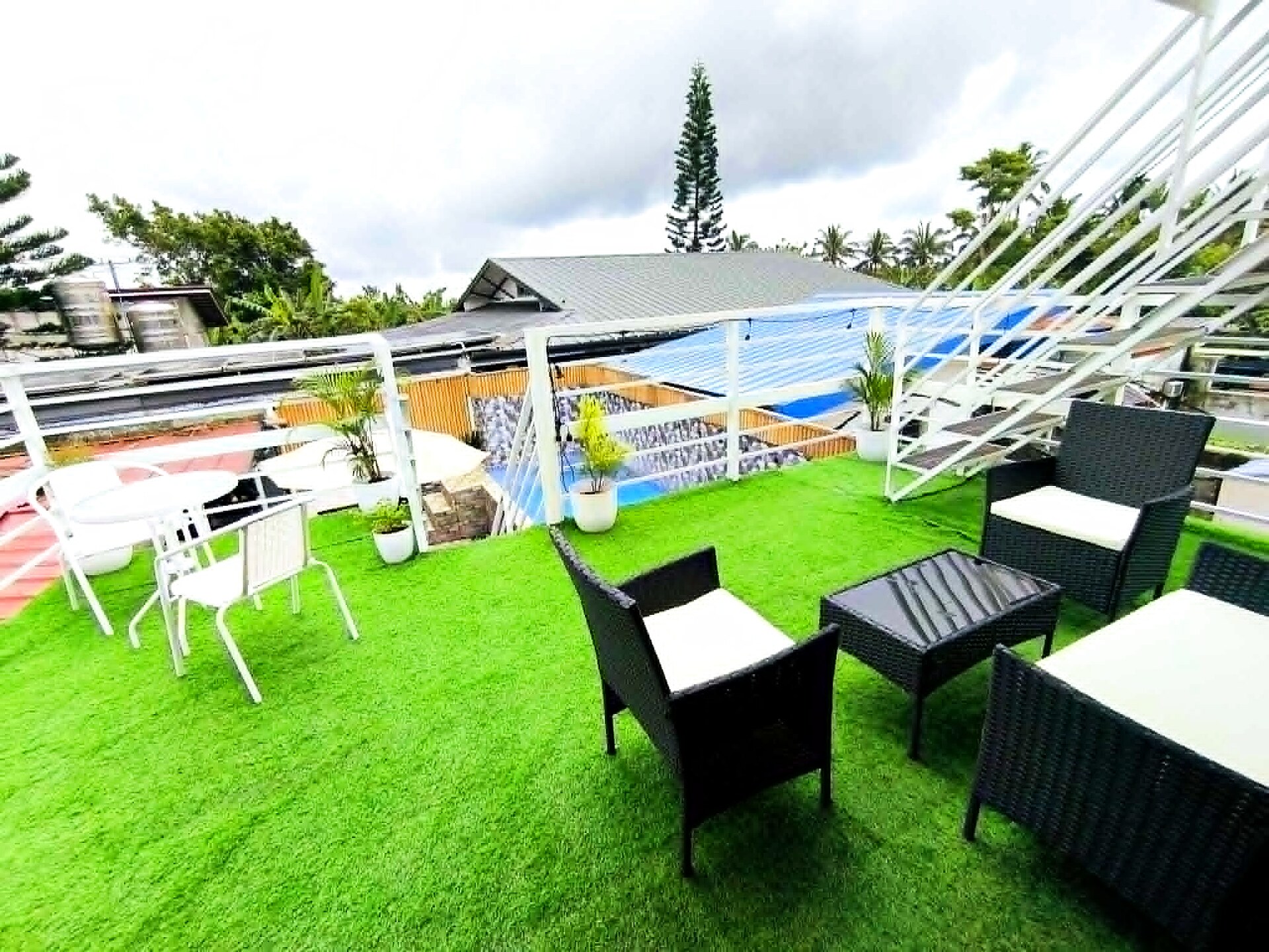 Rooftop seating area with greenery overlooking the pool